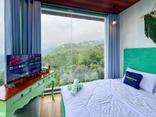 a bedroom with a bed and a large window at Urbanview Hotels Asmaraloka Umbrella in Kejajar