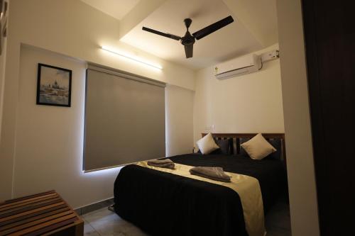 a bedroom with a bed with a ceiling fan at INDIGO Springs in Trivandrum