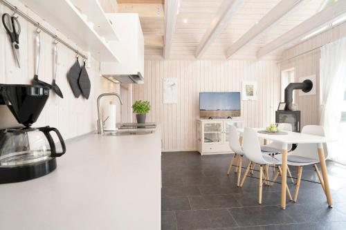 a kitchen with a white table and chairs and a kitchen with a kitchen at Twinhus Süssau in Süssau