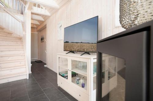 a living room with a flat screen tv on a white cabinet at Twinhus Süssau in Süssau