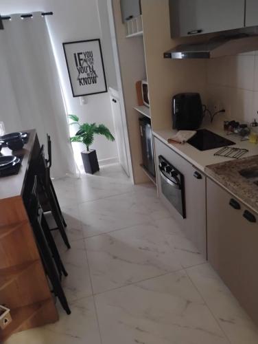 a kitchen with a sink and a stove top oven at Studio Carmenere Com varanda e vista incrível Mogi das Cruzes in Mogi das Cruzes