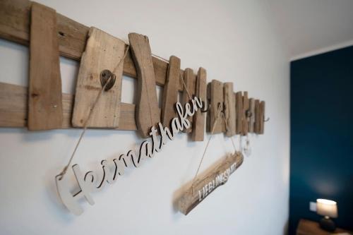 a row of wooden signs hanging on a wall at Residenz am Yachthafen Seaside Marina in Neustadt in Holstein