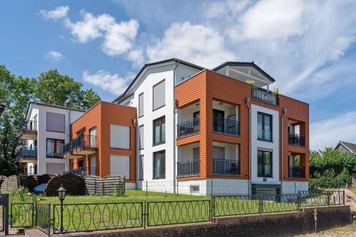 an apartment building with orange and white at Residenz am Yachthafen Seaside Marina in Neustadt in Holstein
