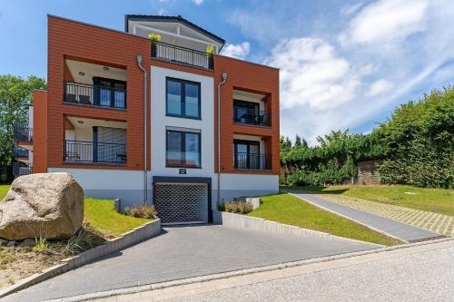 an orange and white building with a driveway at Residenz am Yachthafen Seaside Marina in Neustadt in Holstein
