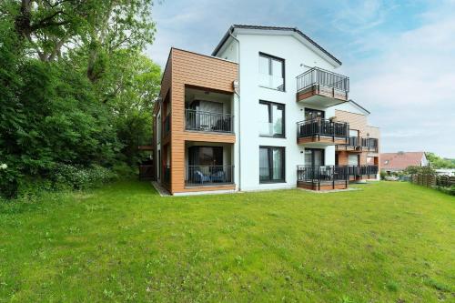 a house with a large yard in front of it at Residenz am Yachthafen Seaside Marina in Neustadt in Holstein
