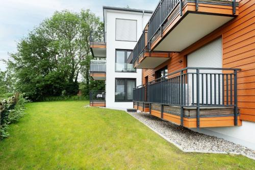 an apartment building with a balcony and a yard at Residenz am Yachthafen Seaside Marina in Neustadt in Holstein
