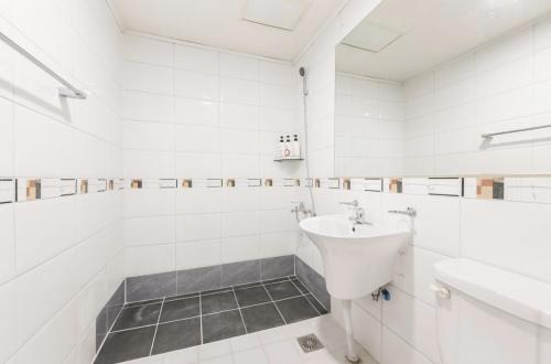 a white bathroom with a sink and a toilet at Vatican Hotel Sangmu in Gwangju