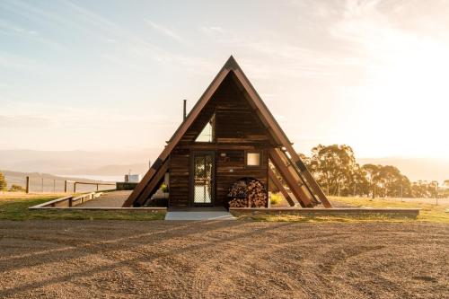 a small cabin with a triangular roof on a field at Skyfarm Retreat in Cradoc