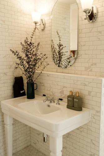 a white bathroom with a sink and a mirror at Skyfarm Retreat in Cradoc