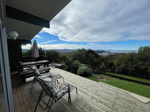 a deck with two chairs and a piano on a house at The Grays in Whangarei