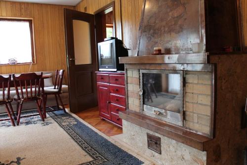 a living room with a fireplace and a tv at Holiday Home Zbilje in Visoko