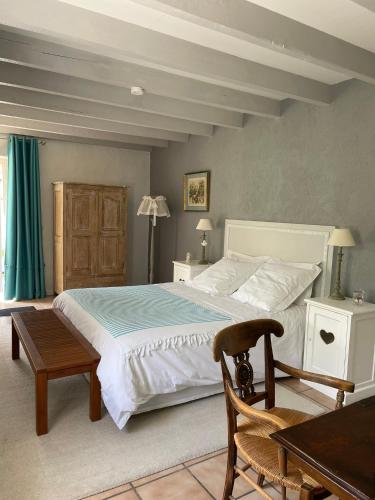 une chambre avec un grand lit blanc et une table dans l'établissement Le Clos du Plantis, à Sonnac
