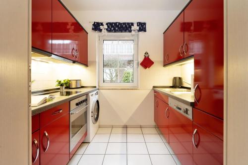 a kitchen with red cabinets and a window at Ferienhaus 17a in Kellenhusen