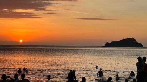 a group of people on the beach at sunset at Apartamento Familiar en Rodadero in Rodadero