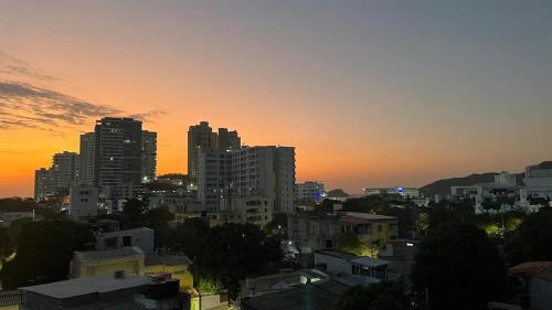 a city skyline at sunset with tall buildings at Apartamento Familiar en Rodadero in Rodadero