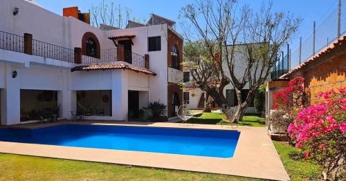 a villa with a swimming pool in front of a house at Casa Ranas in Tlayacapan