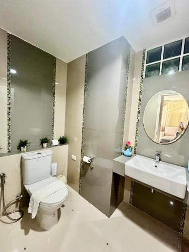 a bathroom with a toilet and a sink and a mirror at Peters Villa in Ban Nakhon Chum