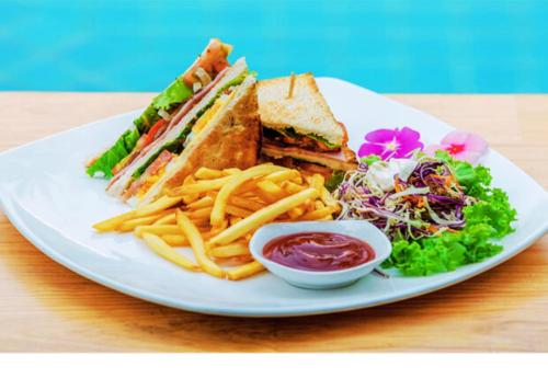 a plate with a sandwich and french fries and a salad at Angkor Home 27 in Phumĭ Réach Born