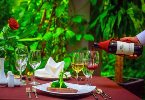 a person pouring wine into wine glasses on a table at Angkor Home 27 in Phumĭ Réach Born