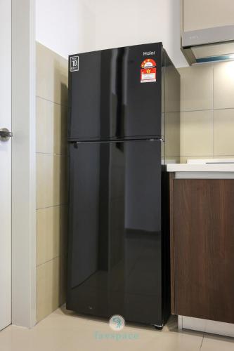 a black refrigerator in the corner of a kitchen at Jalan Puchong - 3B2B - 7 pax - 7 min to AEON BiG & Train in Puchong