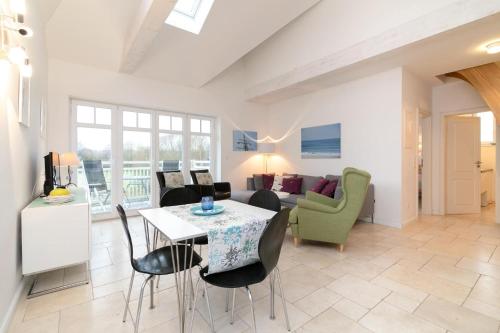 a living room with a table and chairs at Strandallee 53 Sonnendeck in Haffkrug