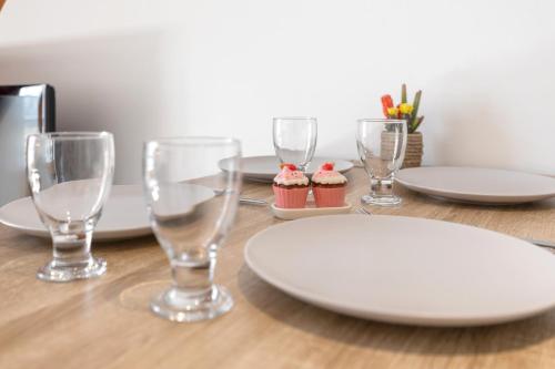 une table avec des assiettes et des verres sur une table en bois dans l'établissement Studio Gare Express - Wifi, Cozy, Privé & Confort, à Montpellier