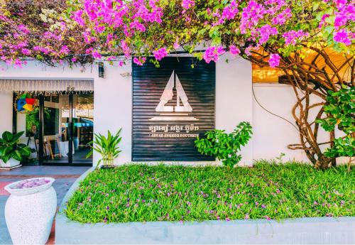 a sign on a store front with pink flowers at Angkor Home 27 in Phumĭ Réach Born