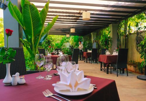 a table with wine glasses and a plate with a flower on it at Angkor Home 27 in Phumĭ Réach Born