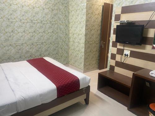 a bedroom with a bed and a television in it at HOTEL ROBIN in Amritsar