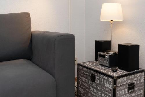 a living room with a chair and a lamp on a box at Solymar Wohnung 22 in Grömitz