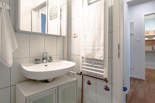 a white bathroom with a sink and a mirror at Solymar Wohnung 22 in Grömitz