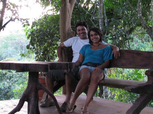 a man and a woman sitting on a wooden bench at Vocaré Finca Agroecológica in Upala