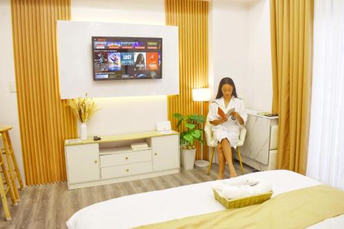 a woman is sitting in a hotel room at Bolo Airport Homestay in Lapu Lapu City