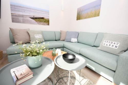 a living room with a blue couch and a table at Heimathafen Dahme in Dahme