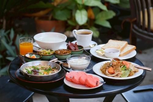 un tavolo nero con piatti di cibo sopra di XX Lunar Mansion Hotel - โรงแรม ลูน่า แมนชั่น เชียงใหม่ a Chiang Mai