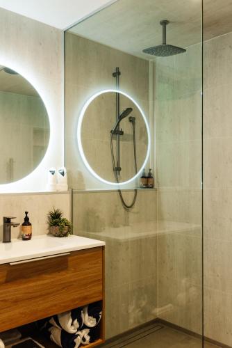 a bathroom with a shower and a sink and a mirror at Golden Bay Beach Retreat in Parapara 