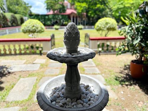 a stone fountain with a cactus in a garden at MiraNamin Nest CALACHUCHI Room in Unique Historic Home - Balcony, Rooftop, Garden View, Shared Kitchen, Pet Friendly with a Fee in Manila