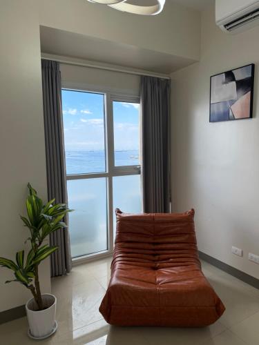 a living room with a couch and a large window at Luxurious Modern Cozy Manila Bayview Pool View 1 2 3 Bedrooms Near Manila Airports Okada Solaire MOA in Manila