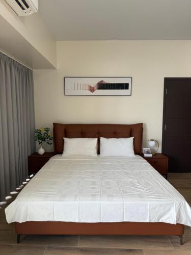a bedroom with a large bed with white sheets at Luxurious Modern Cozy Manila Bayview Pool View 1 2 3 Bedrooms Near Manila Airports Okada Solaire MOA in Manila