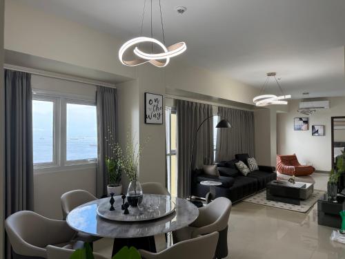 a living room with a table and a couch at Luxurious Modern Cozy Manila Bayview Pool View 1 2 3 Bedrooms Near Manila Airports Okada Solaire MOA in Manila