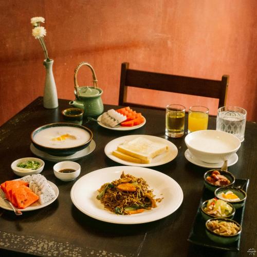 un tavolo nero con piatti di cibo sopra di XX Lunar Mansion Hotel - โรงแรม ลูน่า แมนชั่น เชียงใหม่ a Chiang Mai