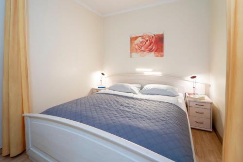 Un dormitorio con una cama con un edredón azul. en Strandappartements am Leuchtturmweg Leuchtturmblick, en Kellenhusen