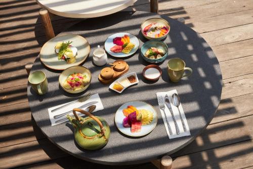 een tafel met daarop borden met eten bij The Purist Beach Nusa Ceningan in Nusa Lembongan
