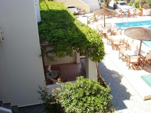 an outdoor patio with chairs and umbrellas and a pool at Galissas Studios in Galissas