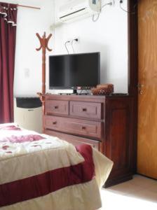 a bedroom with a tv on a dresser with a bed at La Casona de Susana in Colón