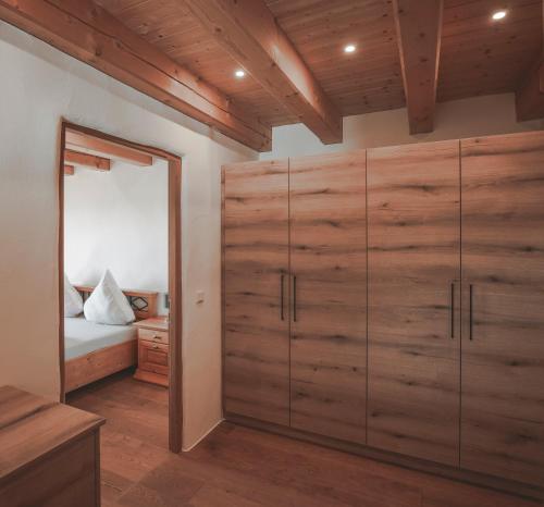 a bedroom with wooden cabinets and a bed and a mirror at Ferienhaus Kaiser in Aßling