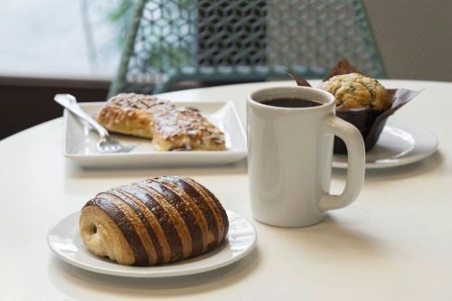a table with plates of pastries and a cup of coffee at Torrance Marriott Redondo Beach in Torrance