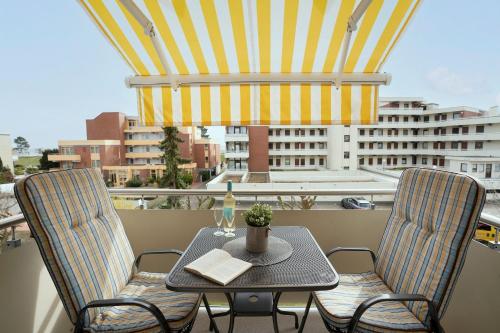 a table and chairs on a balcony with a window at Haus Wiking- Nordstern in Grömitz