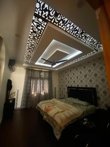 a bedroom with a large bed with a ceiling at Raheel house in Dargai