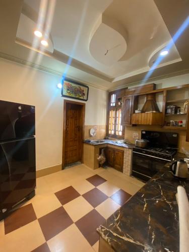 a kitchen with a checkered floor at Raheel house in Dargai